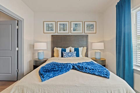 Bedroom with textured headboard and blue accents at Tapestry Orem Apartments, Houston