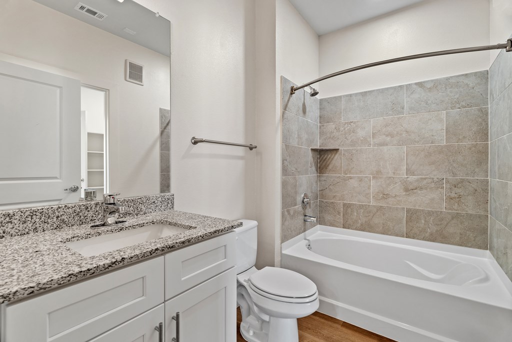 A bathroom with a white toilet, sink, and bathtub at SOSA at Palo Alto Apartments, San Antonio, TX
