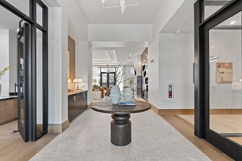 A modern living room with a wooden floor and a large coffee table in the center.