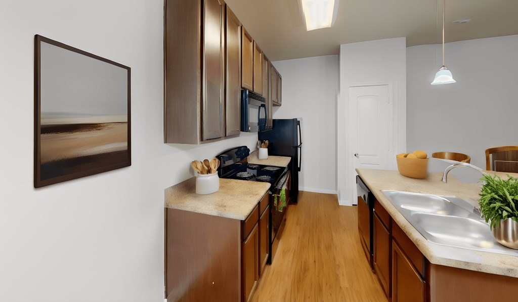a kitchen with wood flooring and wooden cabinets and a black refrigerator