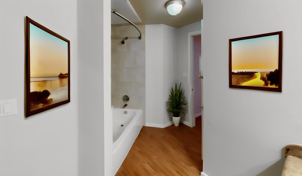 a bathroom with a tub and pictures on the wall