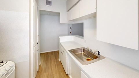 a kitchen with white cabinets and a stainless steel sink