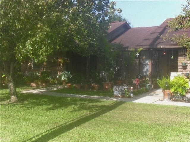 a house with a yard and trees in front of it