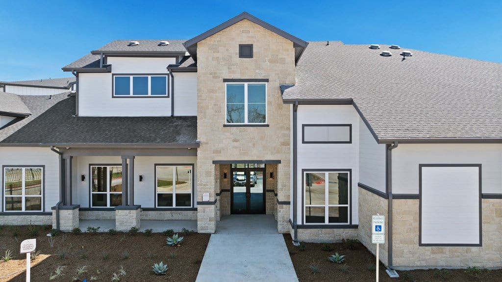 A modern house with a grey roof and a white garage door. A modern house with a grey roof and a white garage door at SOSA at Palo Alto Apartments, Texas
