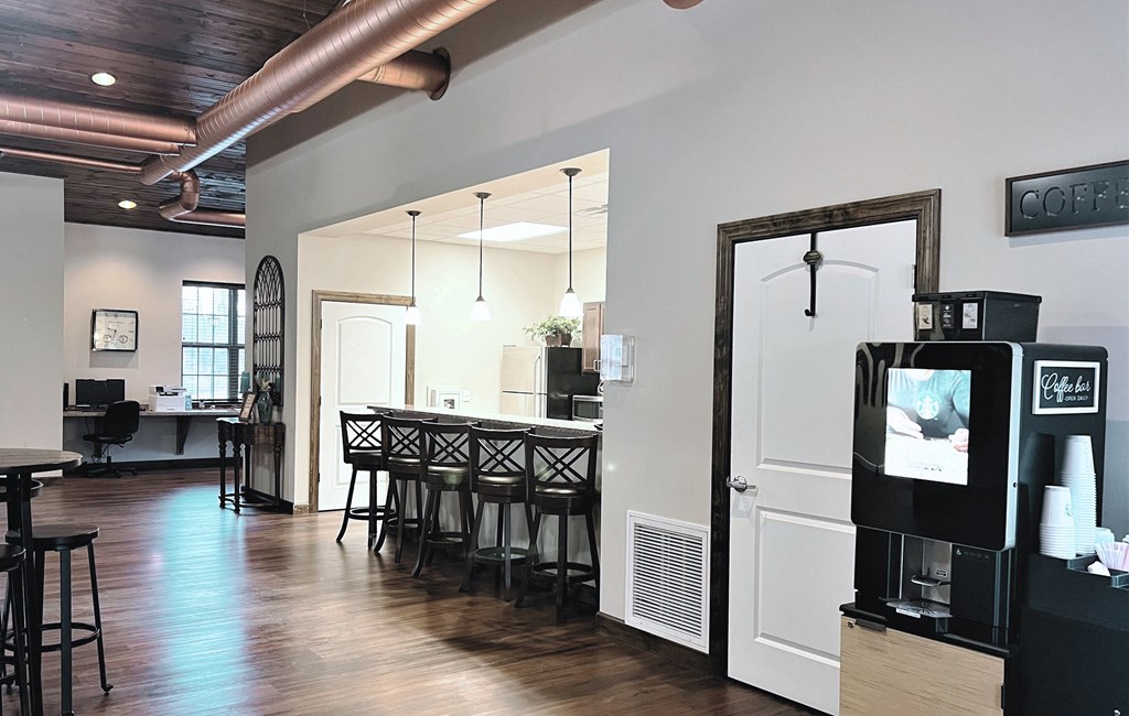 a bar area with a bar stool and a coffee machine