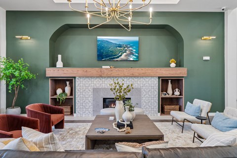 A living room with a fireplace and a painting above it.