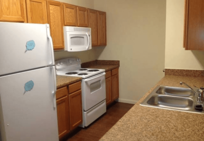 A kitchen with a white fridge and white oven.