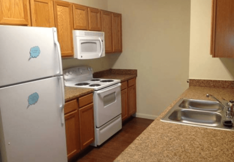 A kitchen with a white fridge and white oven.