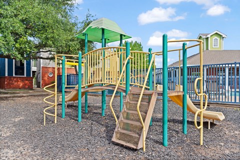 Childrens playground with climbing structure and slides at Country Park Apartments, Denton, TX 76209