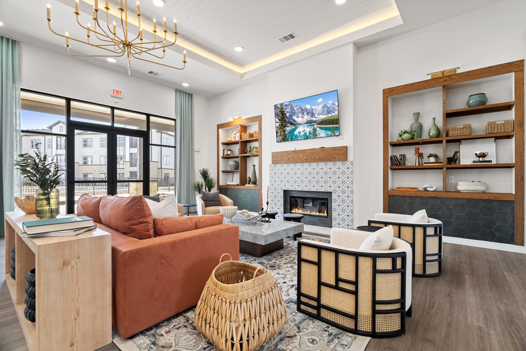 A living room with a fireplace and a TV on the wall. A living room with a fireplace and a TV on the wall at SOSA at Palo Alto Apartments, San Antonio 78224