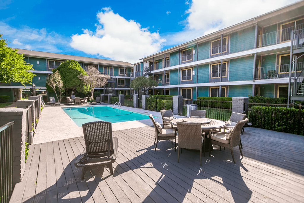 a patio with a pool in front of an apartment building