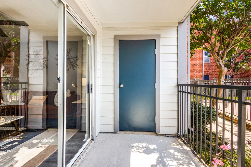 the front door of a white house with a blue door