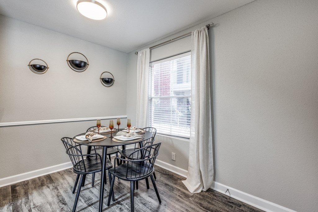 a dining room with a table and chairs and a window