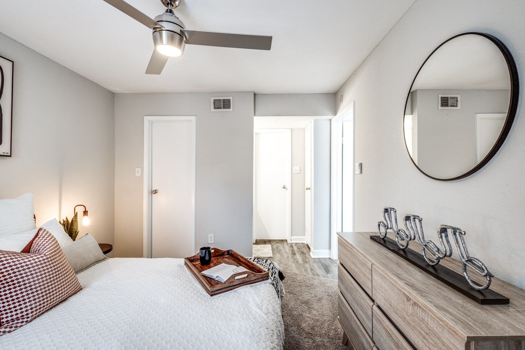 a bedroom with a bed and a dresser and a mirror