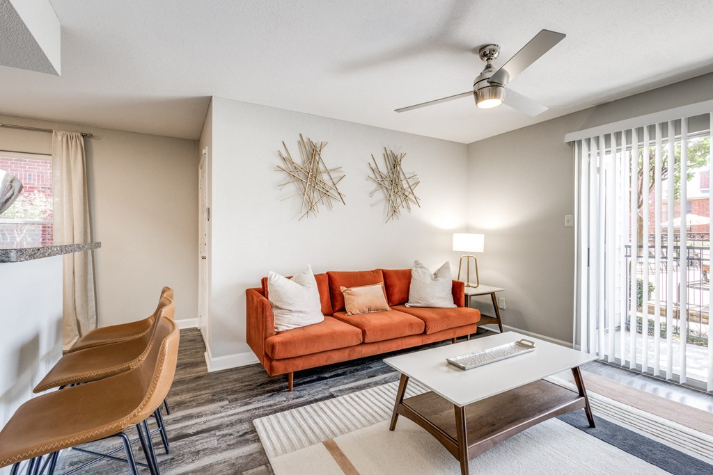 a living room with a couch and a table and a ceiling fan