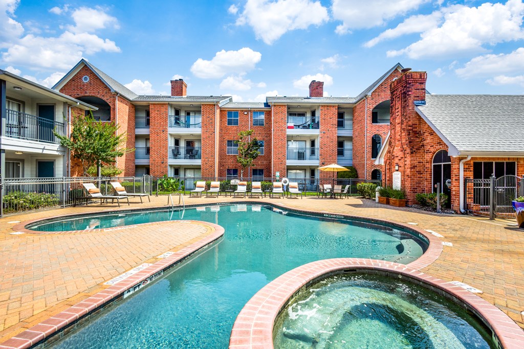 a swimming pool with an apartment building in the background