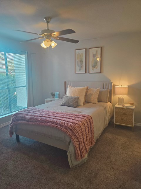 a bedroom with a bed and a ceiling fan