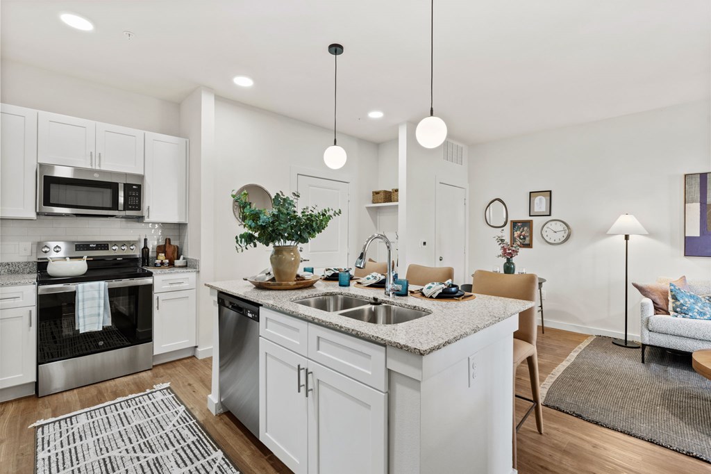 A modern kitchen with white cabinets and stainless steel appliances.