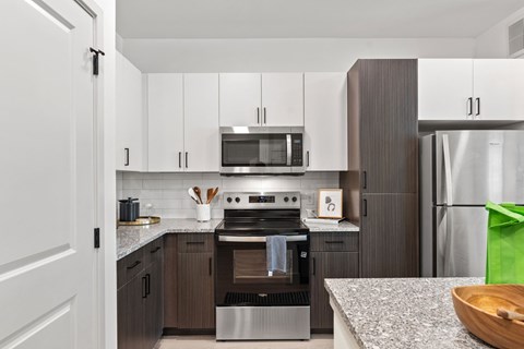 A modern kitchen with a stove top oven and microwave above it.