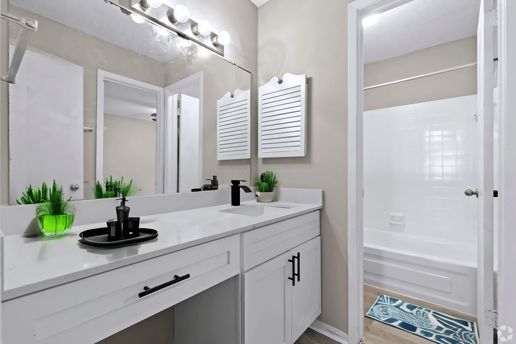 a bathroom with a large mirror and a sink and a shower