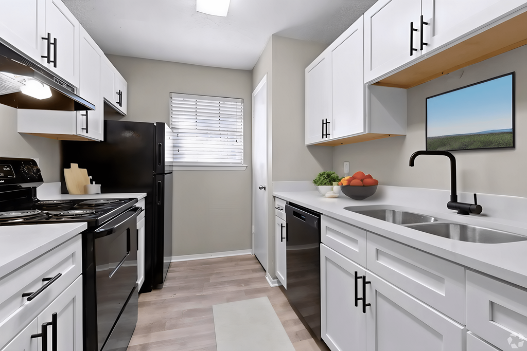an empty kitchen with white cabinets and black appliances and a window