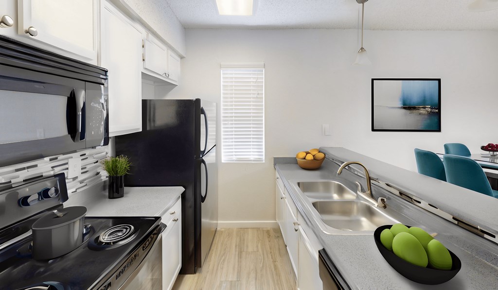 a kitchen with stainless steel appliances and a sink and a refrigerator