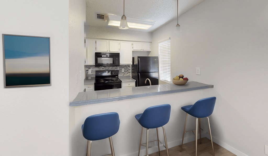 a kitchen with a counter top and three stools