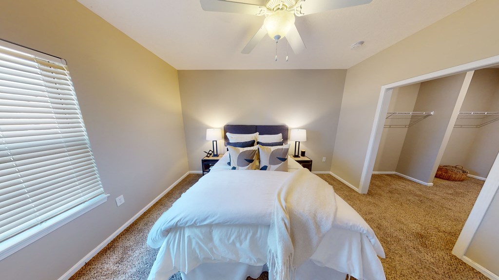 a bedroom with a large bed and a ceiling fan