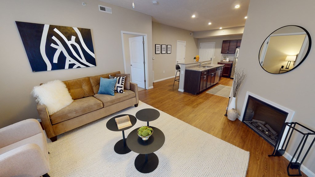a living room with a couch coffee table and a kitchen in the background