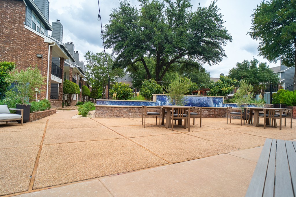 a patio with tables and chairs and a pool