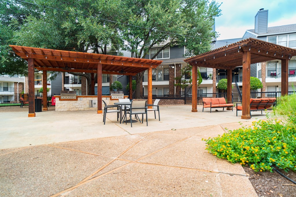 a patio with tables and chairs in front of a building