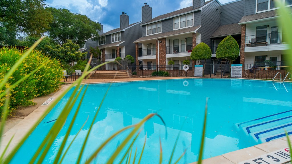 the view of a swimming pool with an apartment building in the background