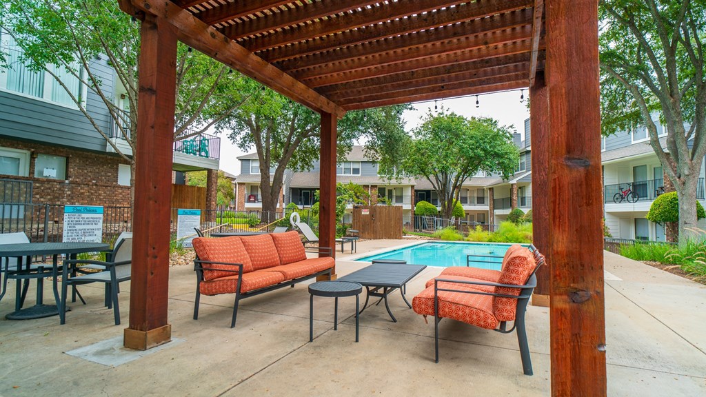 our apartments have a pool and a patio with chairs and tables