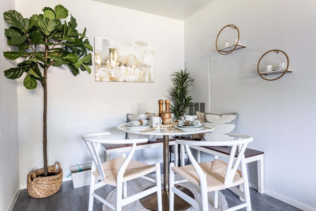a small dining area with two tables and a potted plant