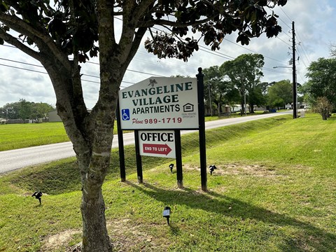 a sign for evangeline village apartments on the side of a road