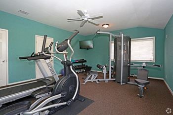 a gym with a ceiling fan and exercise equipment
