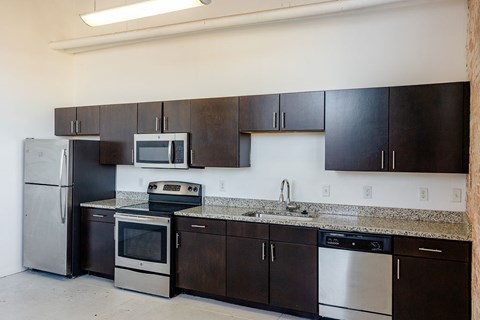 A kitchen with black cabinets and stainless steel appliances.
