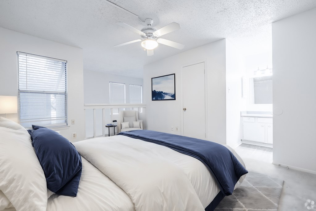 a bedroom with a large bed and a ceiling fan