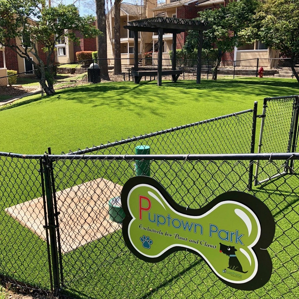 a park with a playground and a sign on a fence