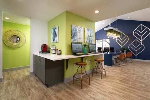 A kitchen with a white counter and bar stools.