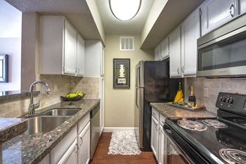 a kitchen with stainless steel appliances and granite counter tops
