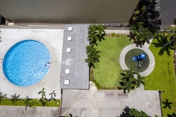 an aerial view of a swimming pool and lawn with a blue