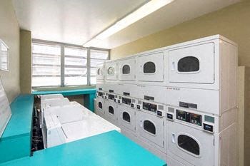 a laundromat with lots of white washers and dryers