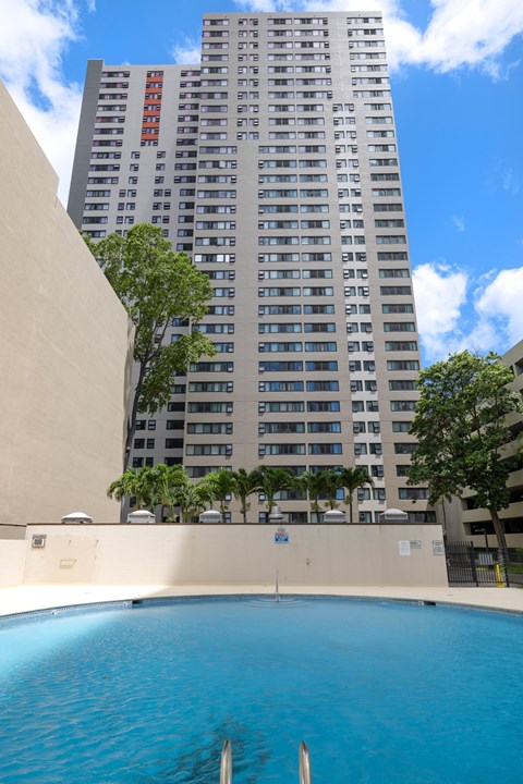 A tall building with a pool in front of it.