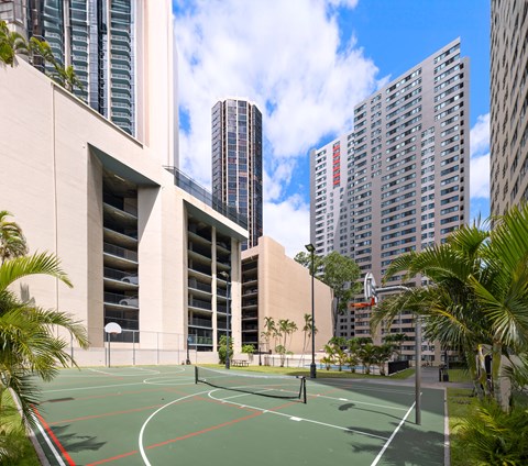 A basketball court is surrounded by tall buildings.