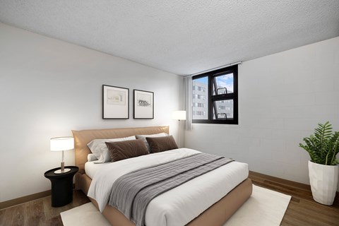A bedroom with a large bed and a potted plant.