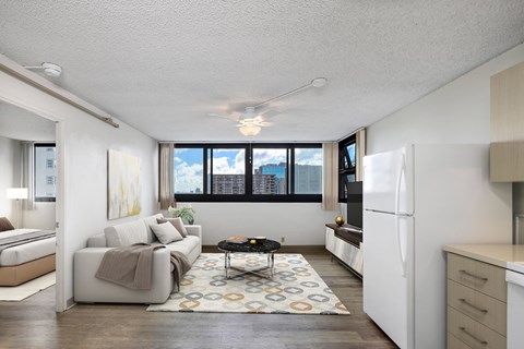 A living room with a couch, a coffee table, and a large window.