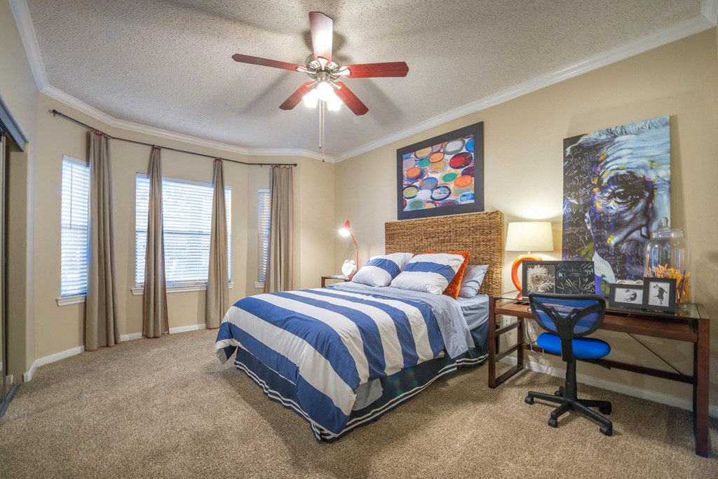the master bedroom has a large bed and a ceiling fan