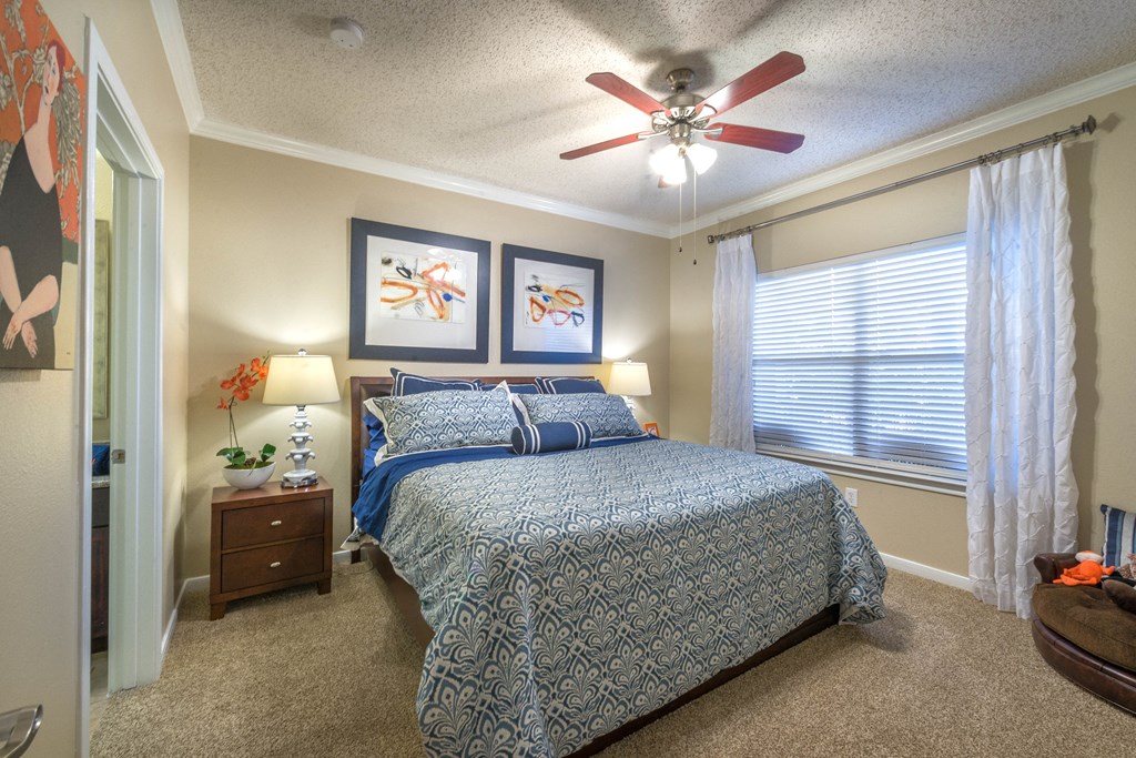 a bedroom with a bed and a ceiling fan