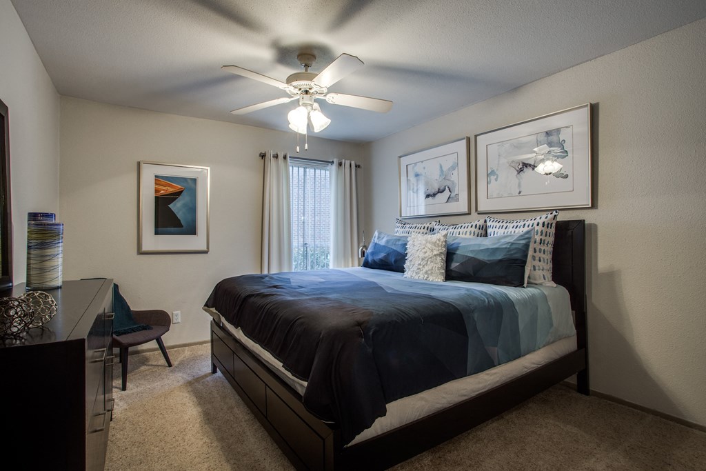 our master bedroom has a large bed and a ceiling fan